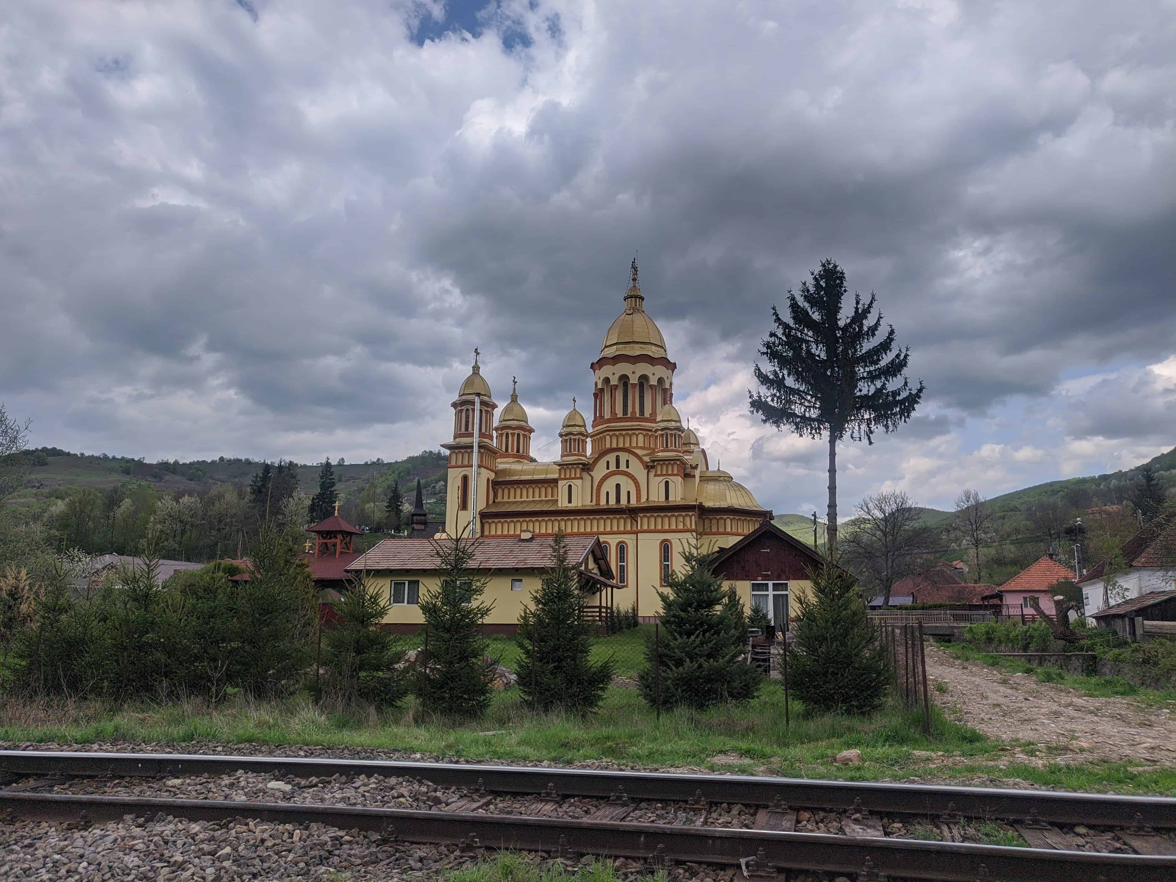 Following the understated railway tracks just over the border into Cluj County, with a rather tacky looking gilded chapel across the way.
